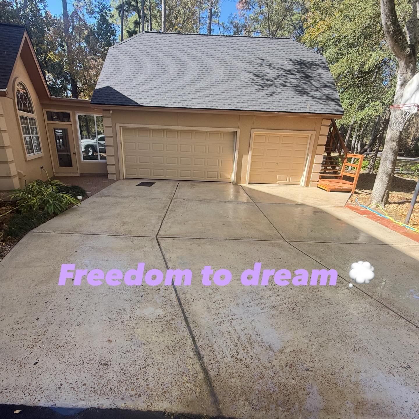 Driveway leading to a beige garage and house, with “Freedom to dream” text overlaid near the bottom.