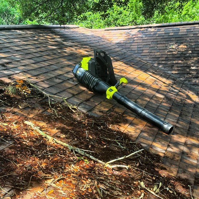 A man is cleaning the gutter system  a high pressure washer.