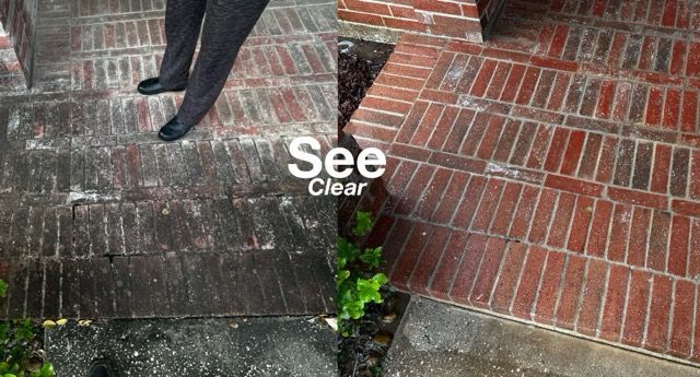 A person is cleaning a patio with a high pressure washer.