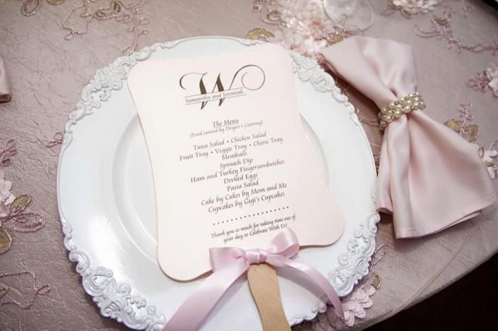 Elegant wedding invitation on a lace-trimmed white plate with pink ribbon and folded napkin