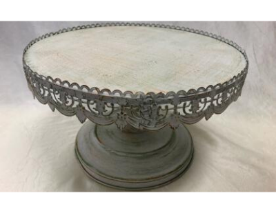 Ornate silver pedestal cake stand with scalloped rim and decorative scrollwork.