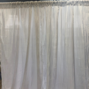 White sheer curtains hanging across a window, softly lit from behind
