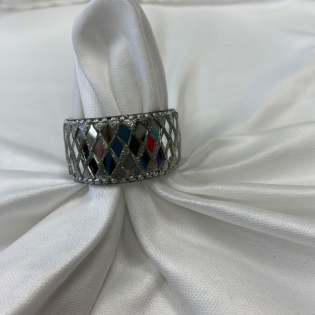 White satin fabric gathered around a silver diamond-patterned ring with red, blue, and black accents.