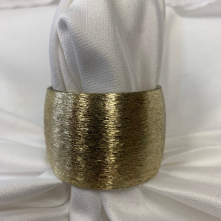 Gold metal ring cinching white fabric against a white background
