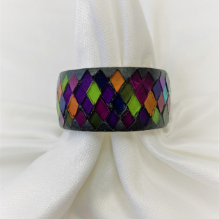 Colorful mosaic-patterned ring on white fabric folds