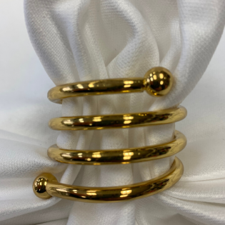 Three gold spiral rings on white satin fabric