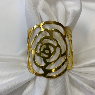 Gold floral cutout ring on white fabric background