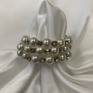 Pearl and silver beaded ring on white satin fabric