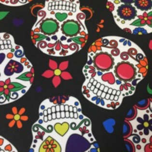 Colorful sugar skull pattern on a black background, with green, red, and purple floral designs