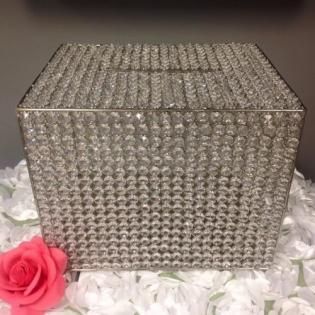 Sparkly silver rhinestone box on white flowers with a pink rose in the corner