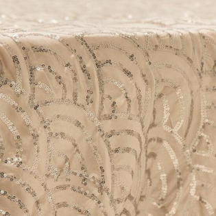 Beige fabric with gold sequin swirl pattern close-up