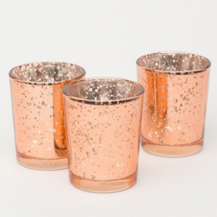 Three copper-toned speckled glass candle holders on a white background
