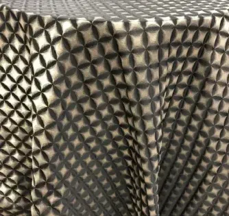 Close-up of black-and-beige textured fabric with a geometric triangular pattern