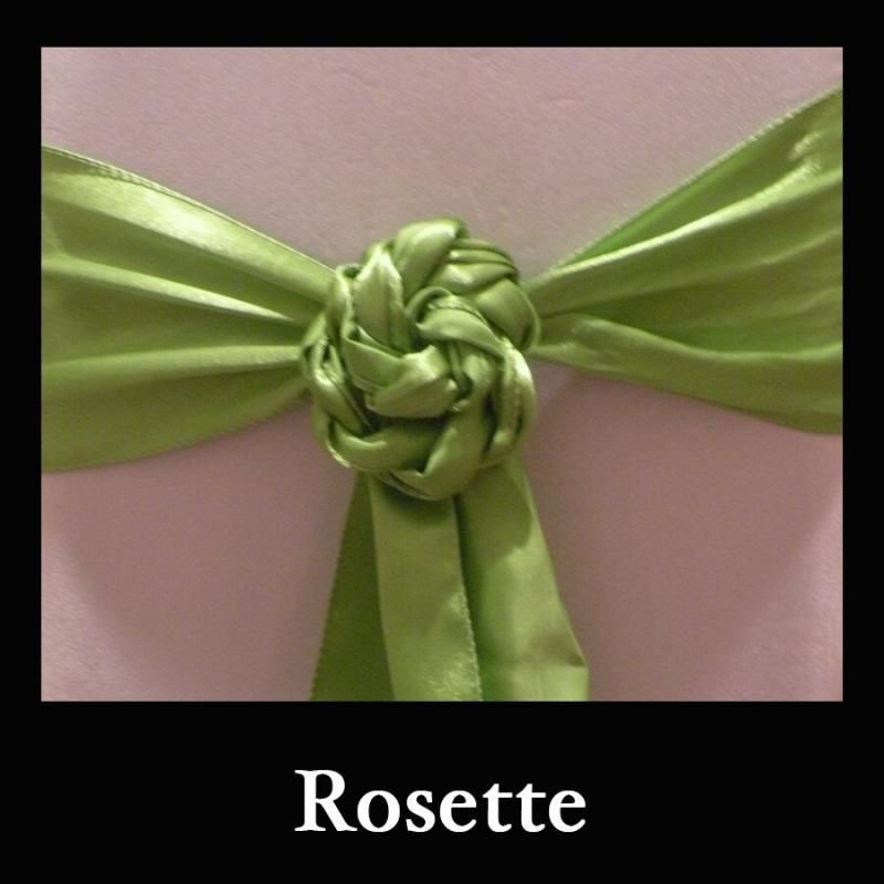 Green satin rosette ribbon bow on a pink background