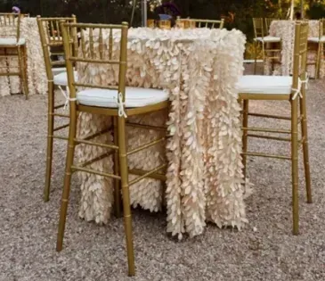 Gold chairs around a beige floral table at an outdoor event