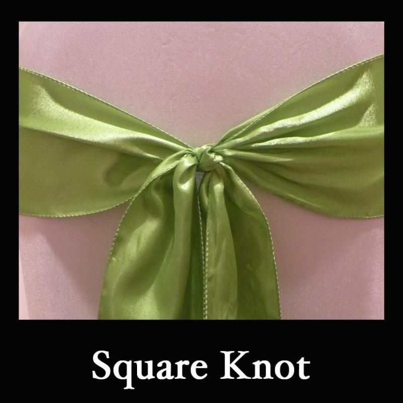 Green satin ribbon tied in a square knot on a pink background