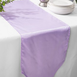 Lavender table runner on a white table with stacked plates at the top right