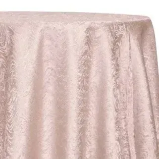 Light pink textured tablecloth draped over a round table