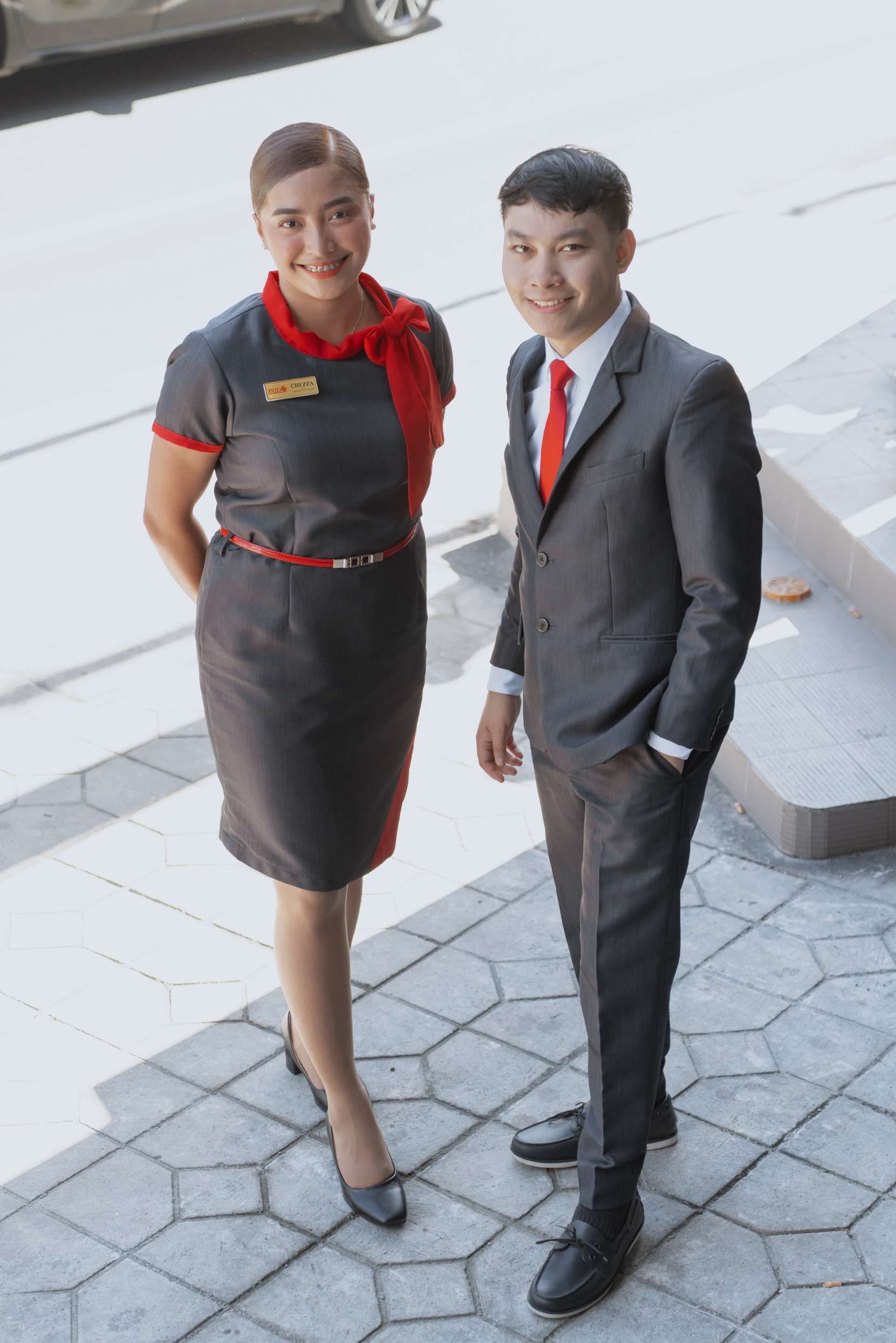 A man and a woman are standing next to each other on a sidewalk.