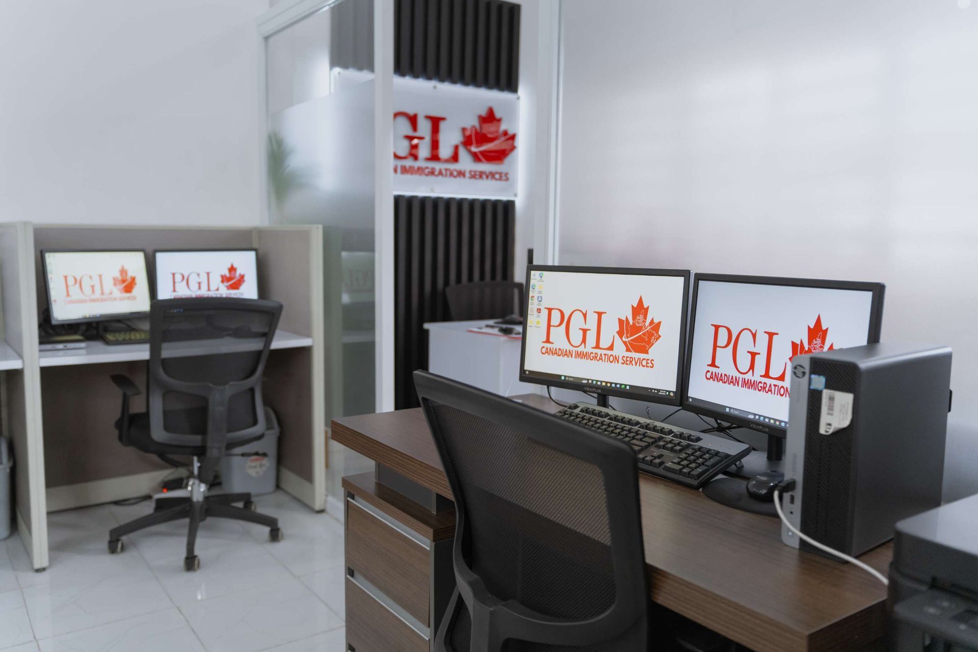 A computer desk with three monitors and a printer in a room.
