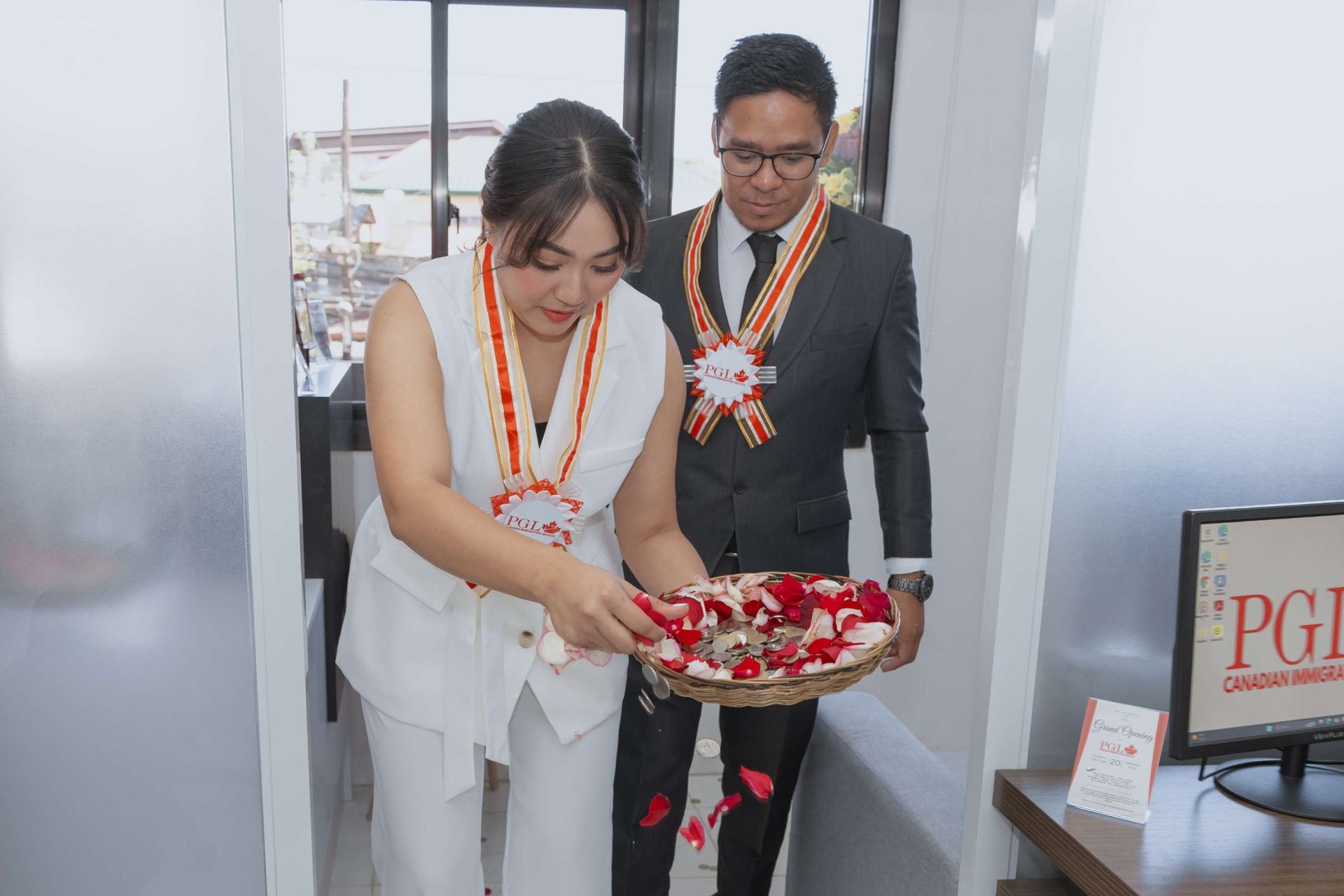 A man and a woman are standing next to each other holding a basket of flowers.