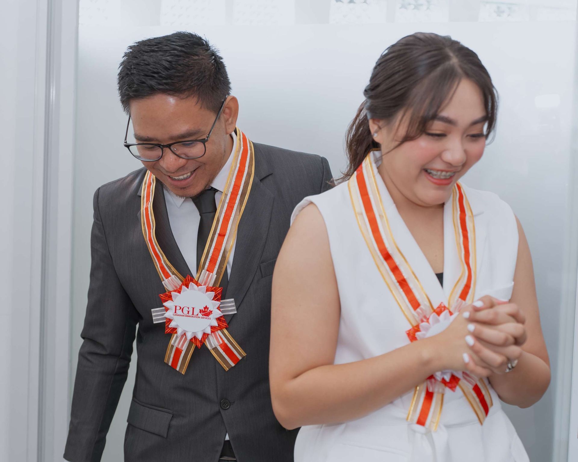A man in a suit and tie is standing next to a woman in a white dress.