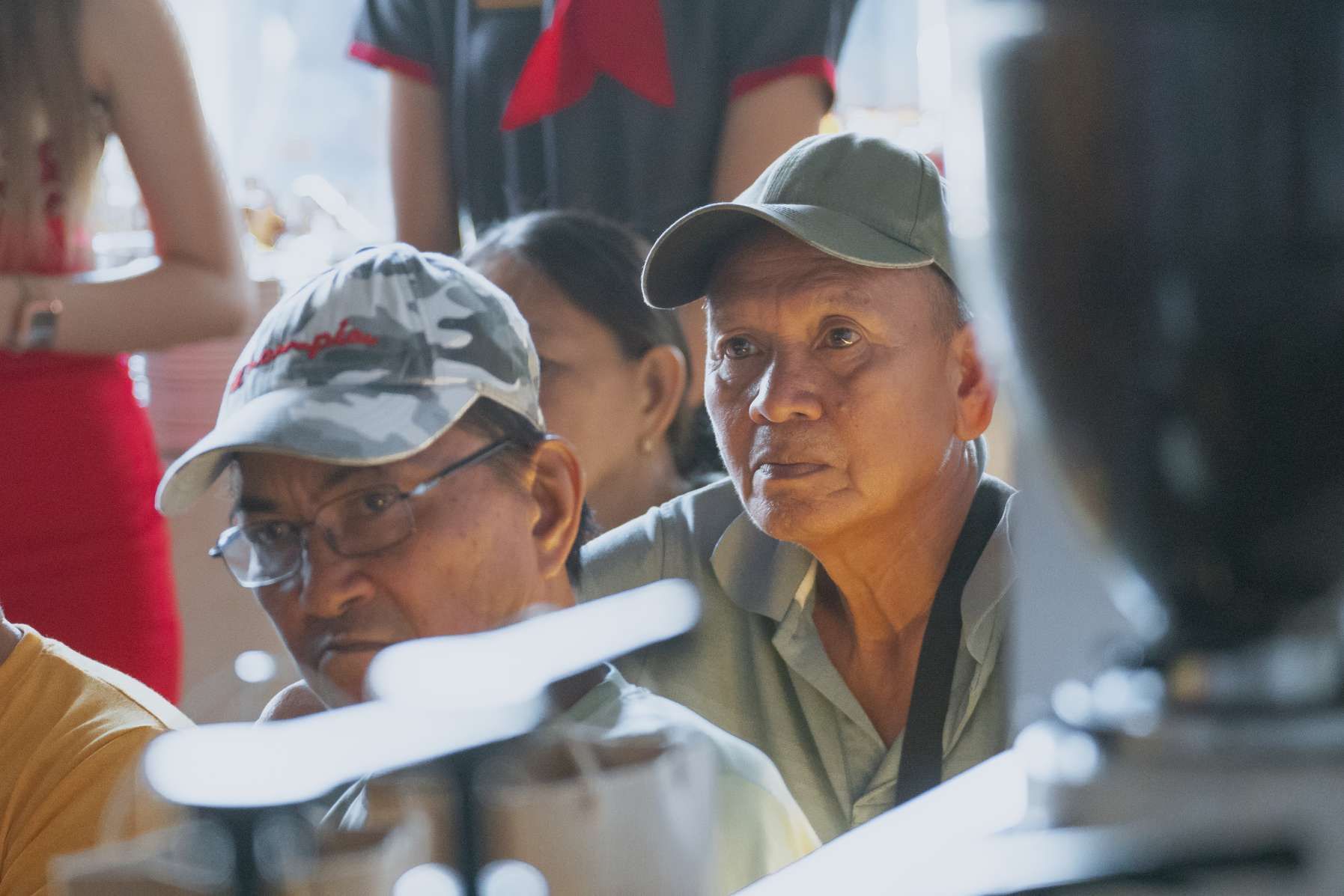 A group of people are sitting at a table looking at something.