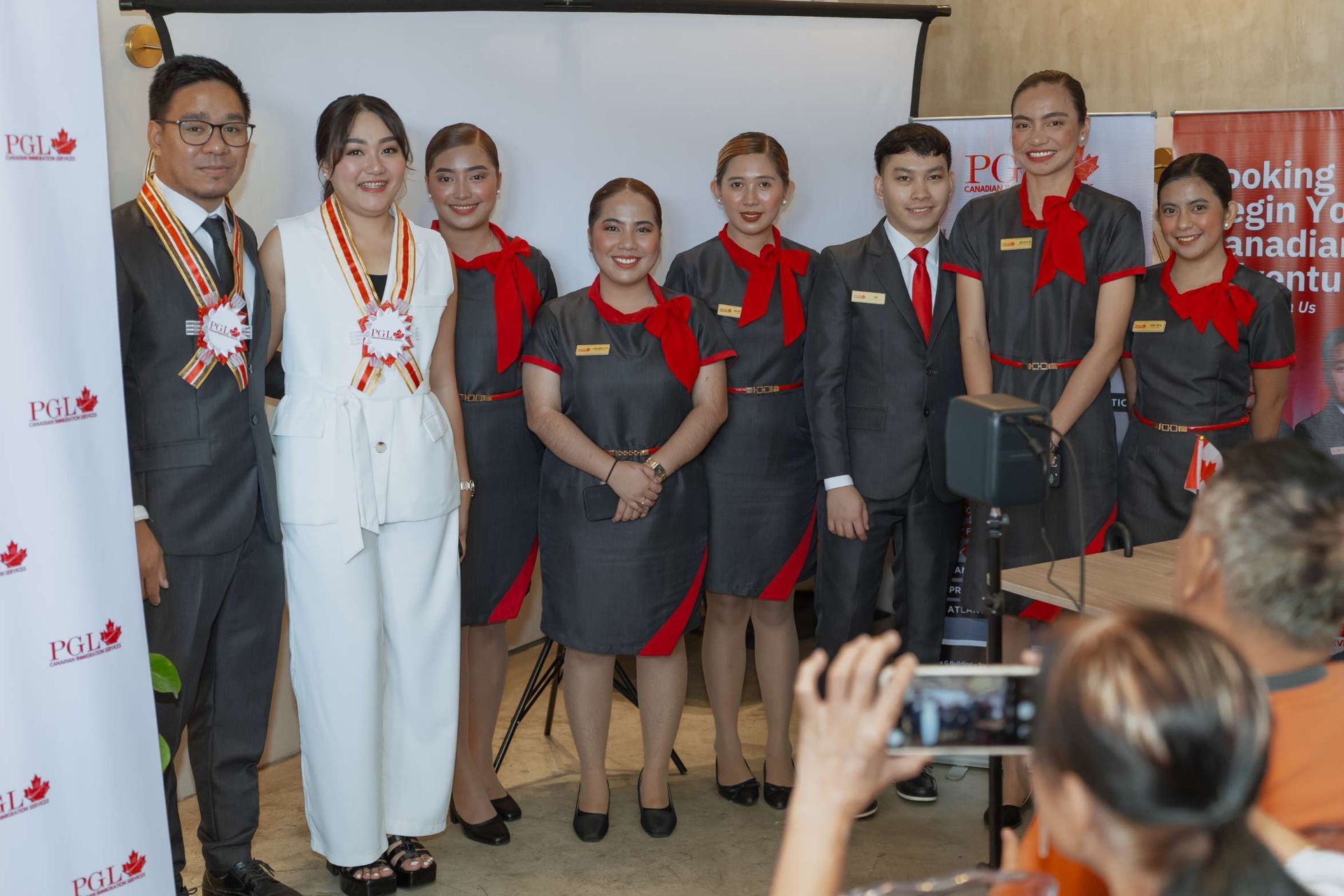 A group of people are posing for a picture in front of a projector screen.
