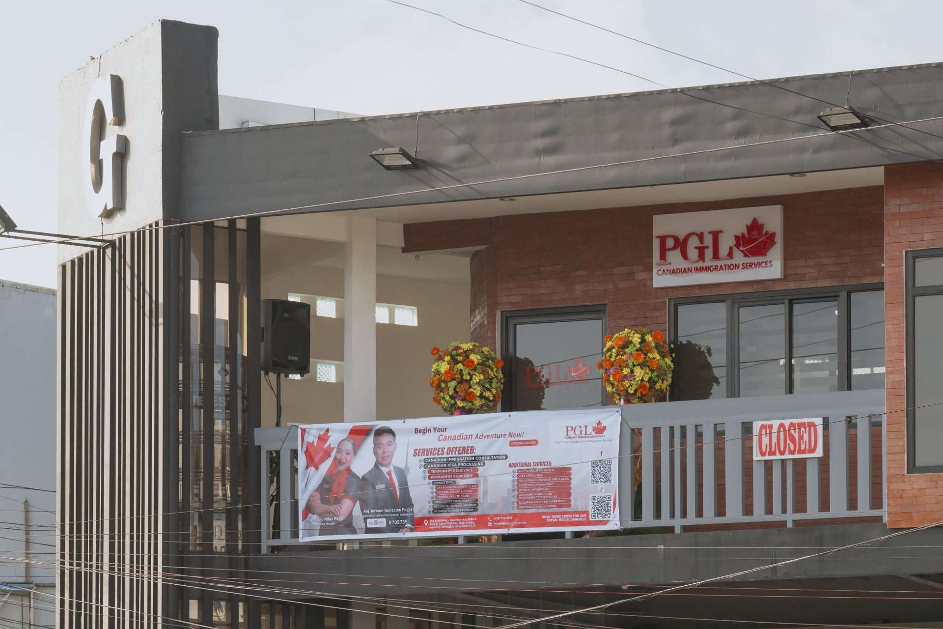 A large building with a balcony and a sign that says pgl on it.