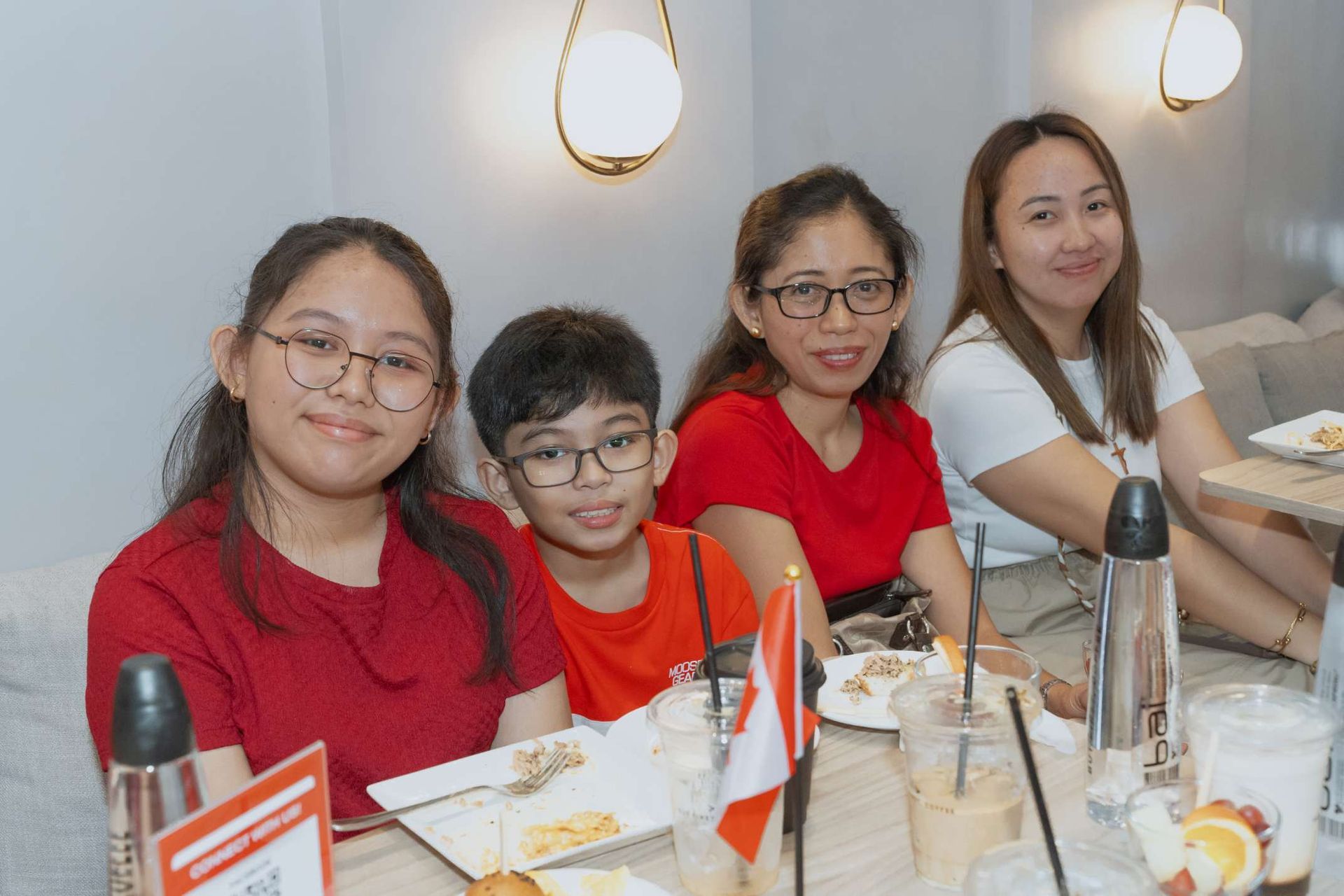 A group of people are sitting at a table with plates of food.