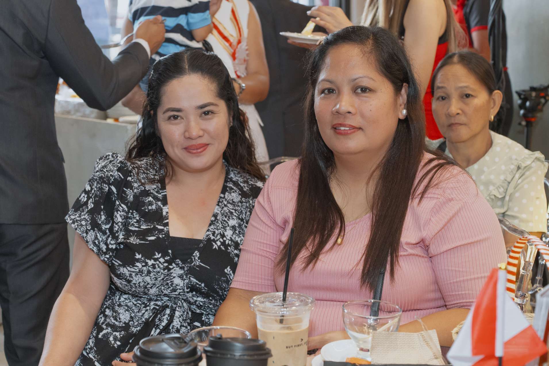 Two women are sitting at a table with cups of coffee
