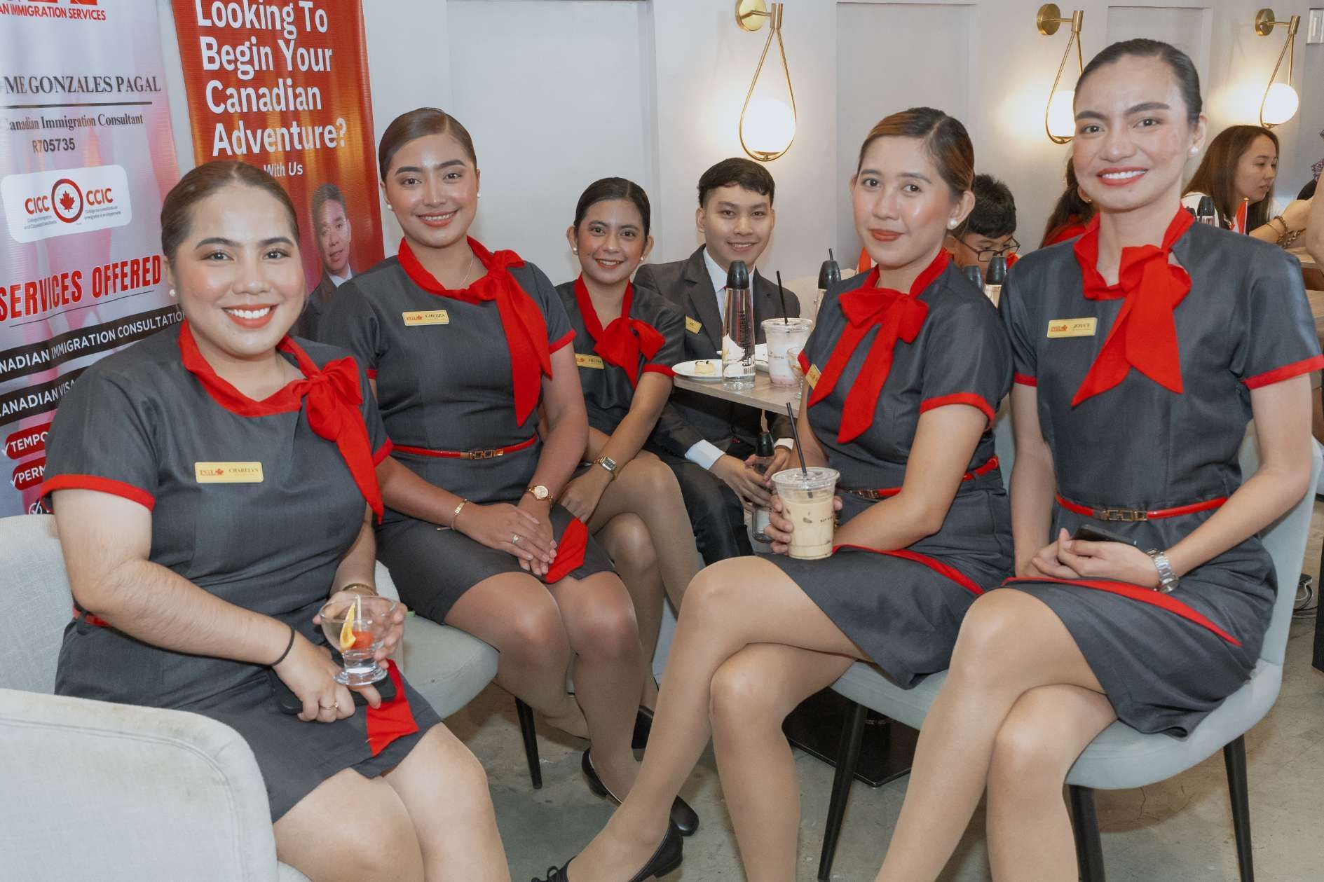 A group of flight attendants are sitting on chairs in a room.