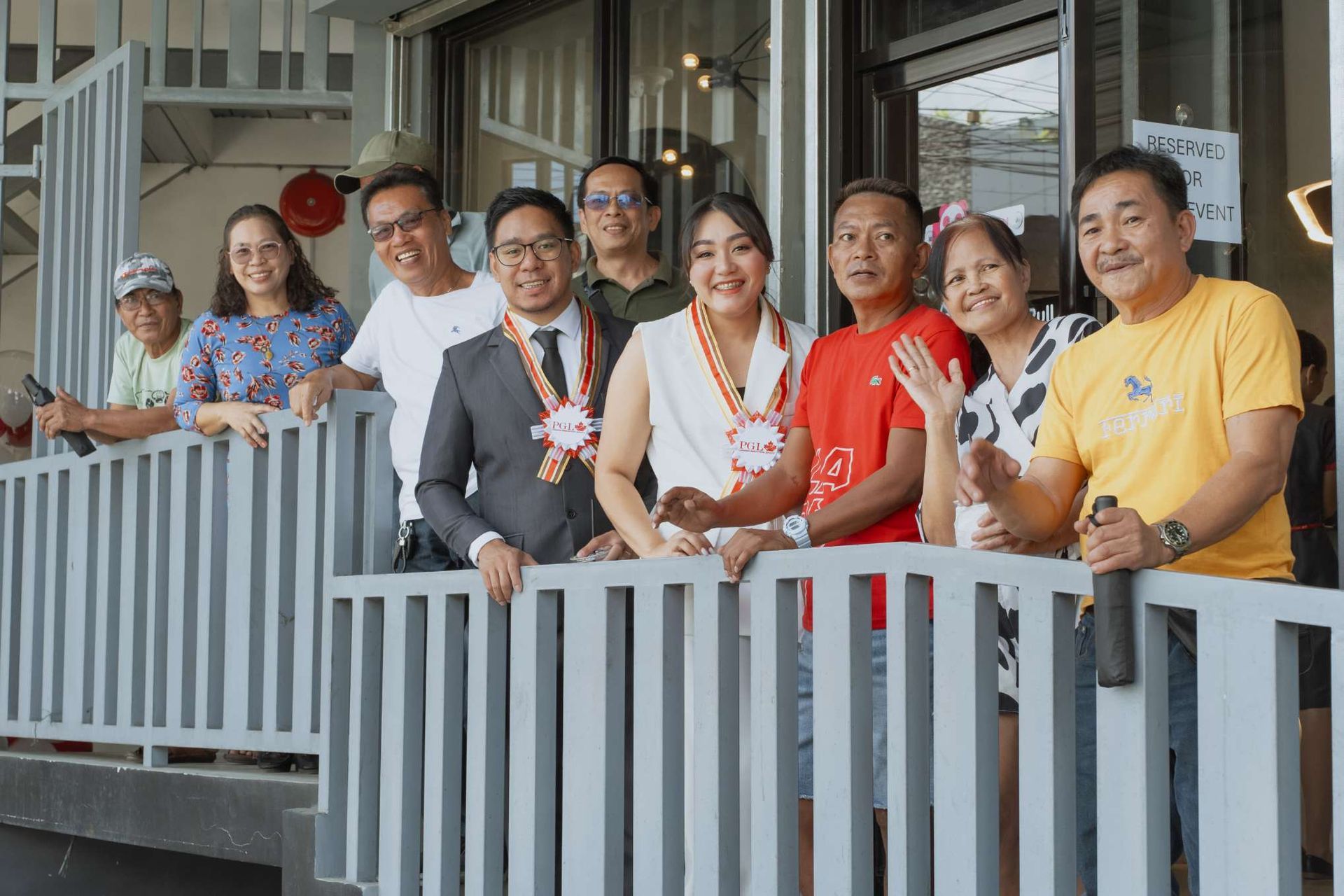 A group of people are standing next to each other on a balcony.