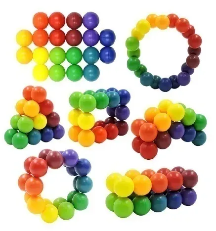 Esferas de caramelos de colores dispuestas en seis patrones circulares y agrupados de arcoíris sobre un fondo blanco.