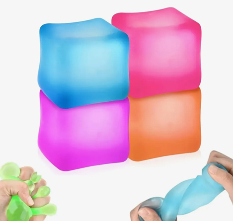 Cuatro coloridos cubos blandos apilados con manos apretando pelotas antiestrés verdes, azules y rosas cerca