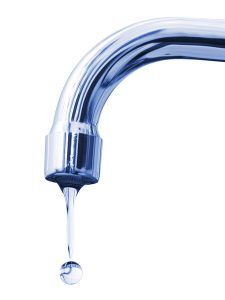 Chrome faucet with water droplet falling.