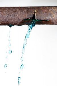 Rusty pipe leaking blue liquid.