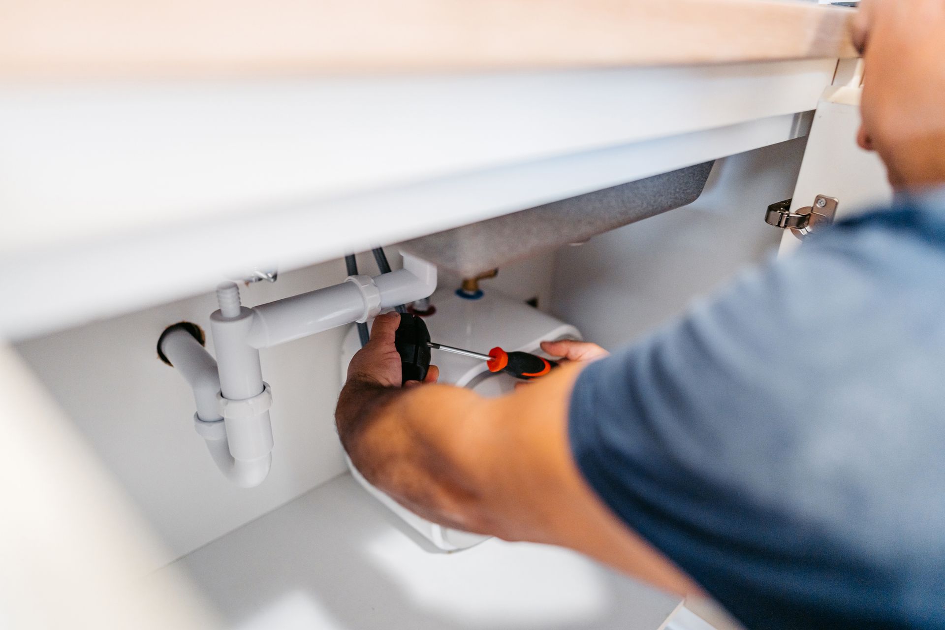 Plumber performing late-summer plumbing maintenance in an Olympia, Washington home.