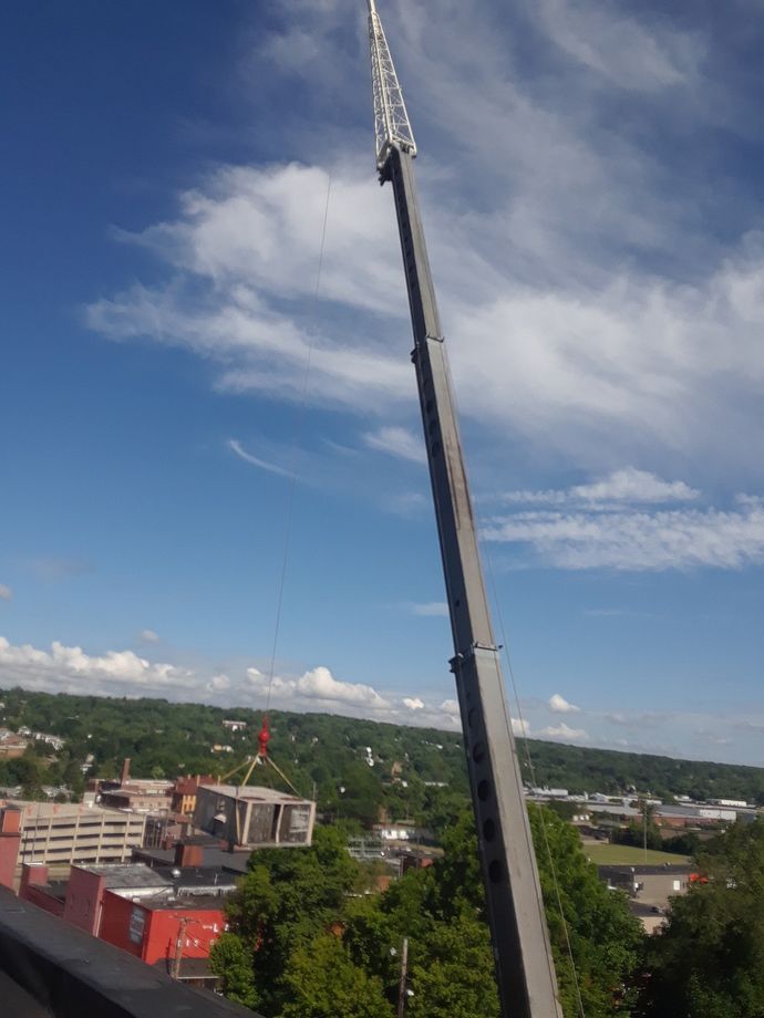 A very tall crane is being used to lift a building
