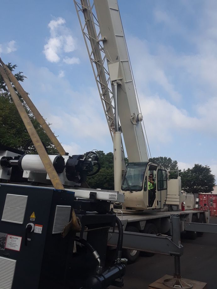 A large crane is parked on the side of the road