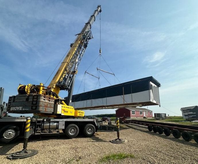A large crane is lifting a building into the air.