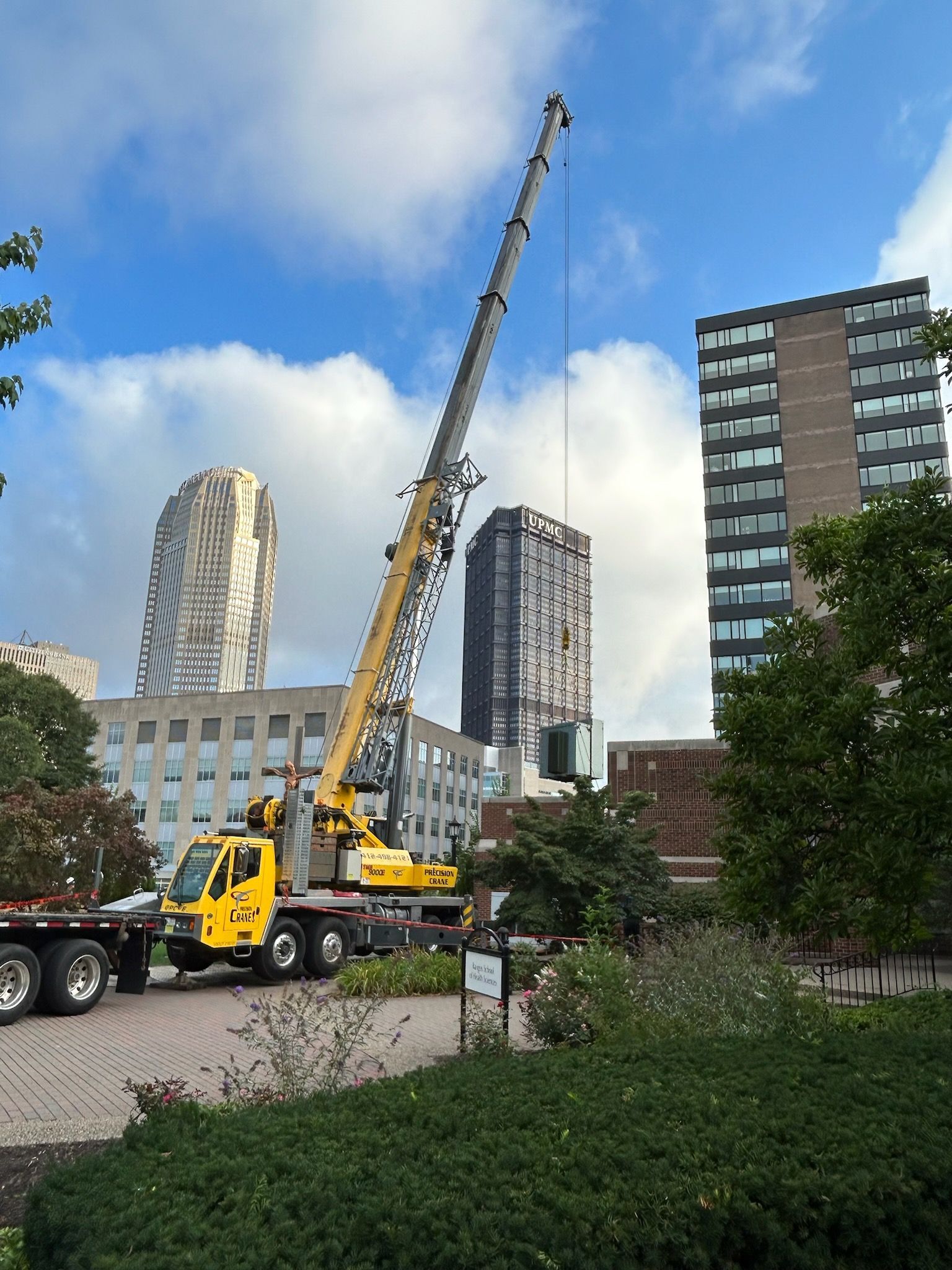 A large yellow truck is parked in front of a city skyline