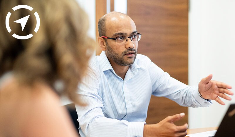 a man is sitting at a table talking to a woman .