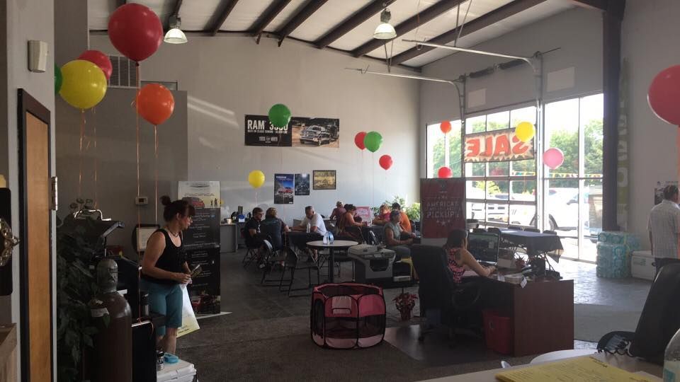 Bright indoor café with hanging balloons, seated people, and sunlight through front windows