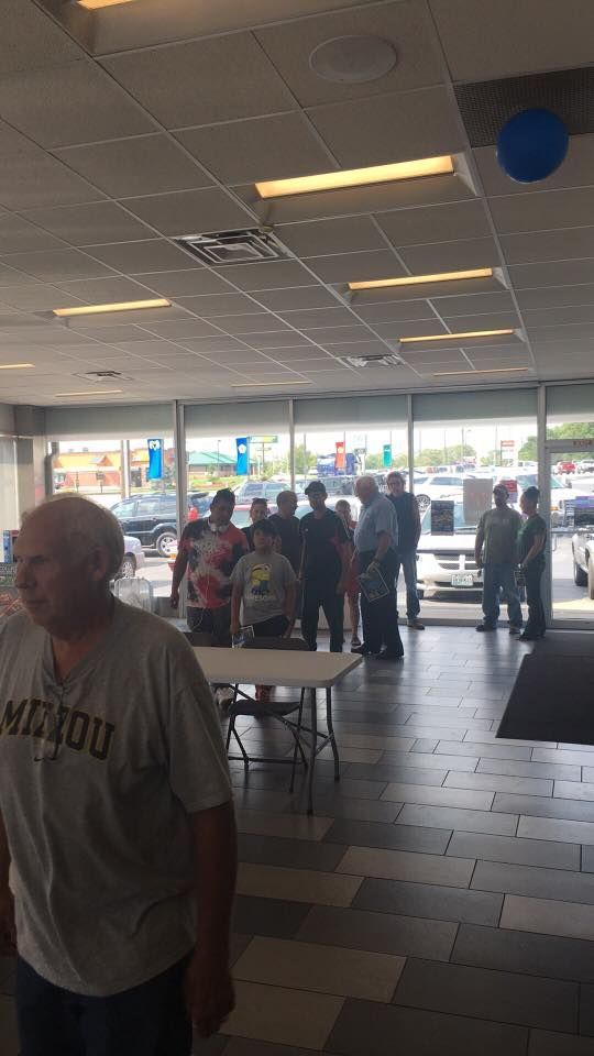 Busy fast-food dining area with people near the counter and tables under bright ceiling lights