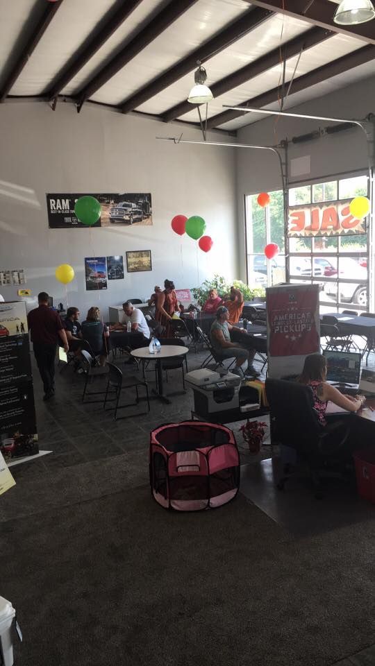Busy café interior with people seated at tables, balloons on the wall, and bright storefront windows