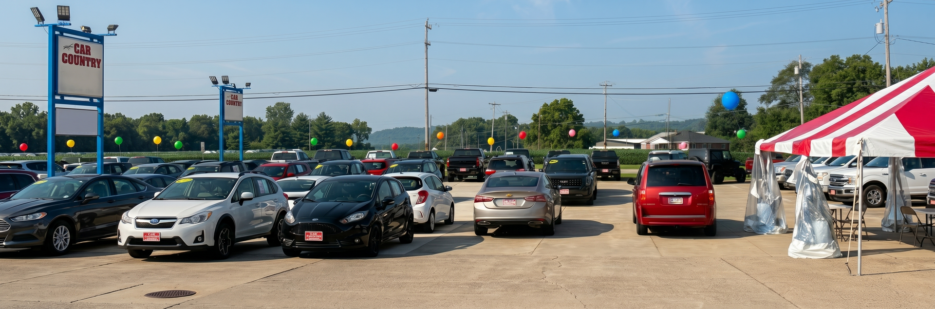 Parking lot with several cars under a clear blue sky, and a red-and-white canopy at right.