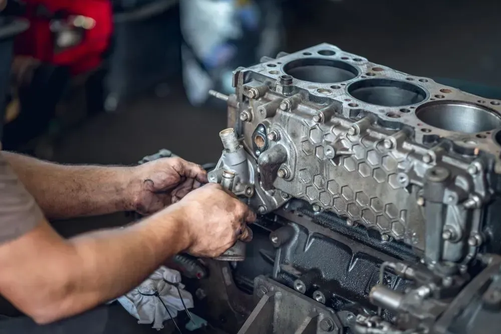 Mechanic's Hands Working on Engine Block in a Garage — Chester's Mechanical & Performance in Tamworth, NSW