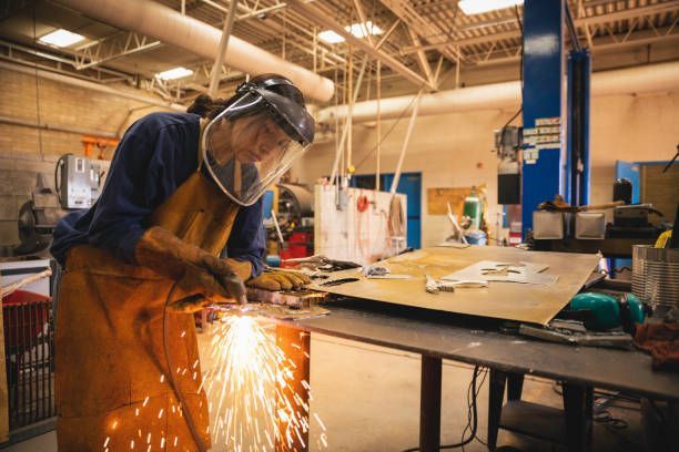 Young teenage woman welding