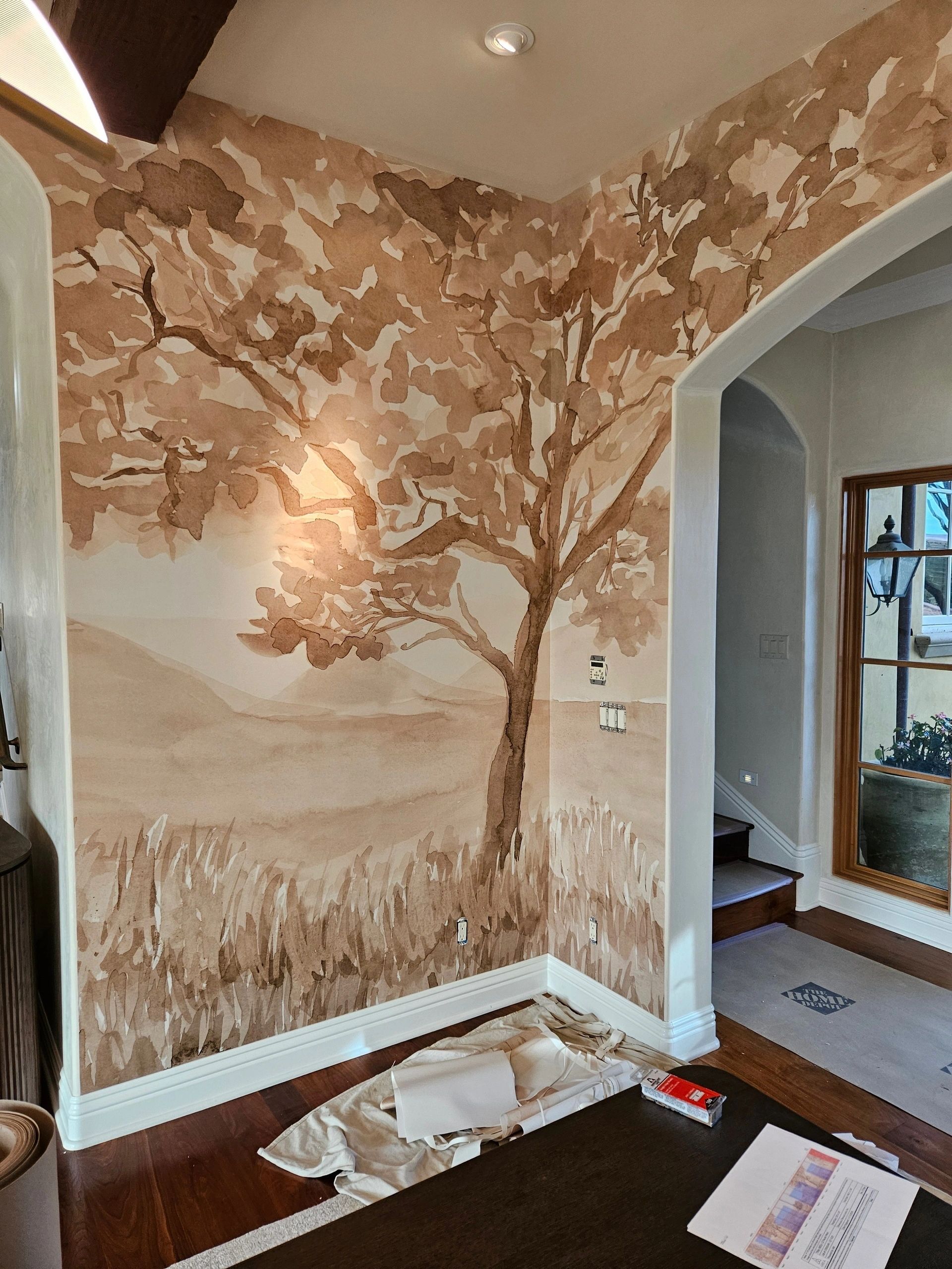 A living room with a painting of a tree on the wall